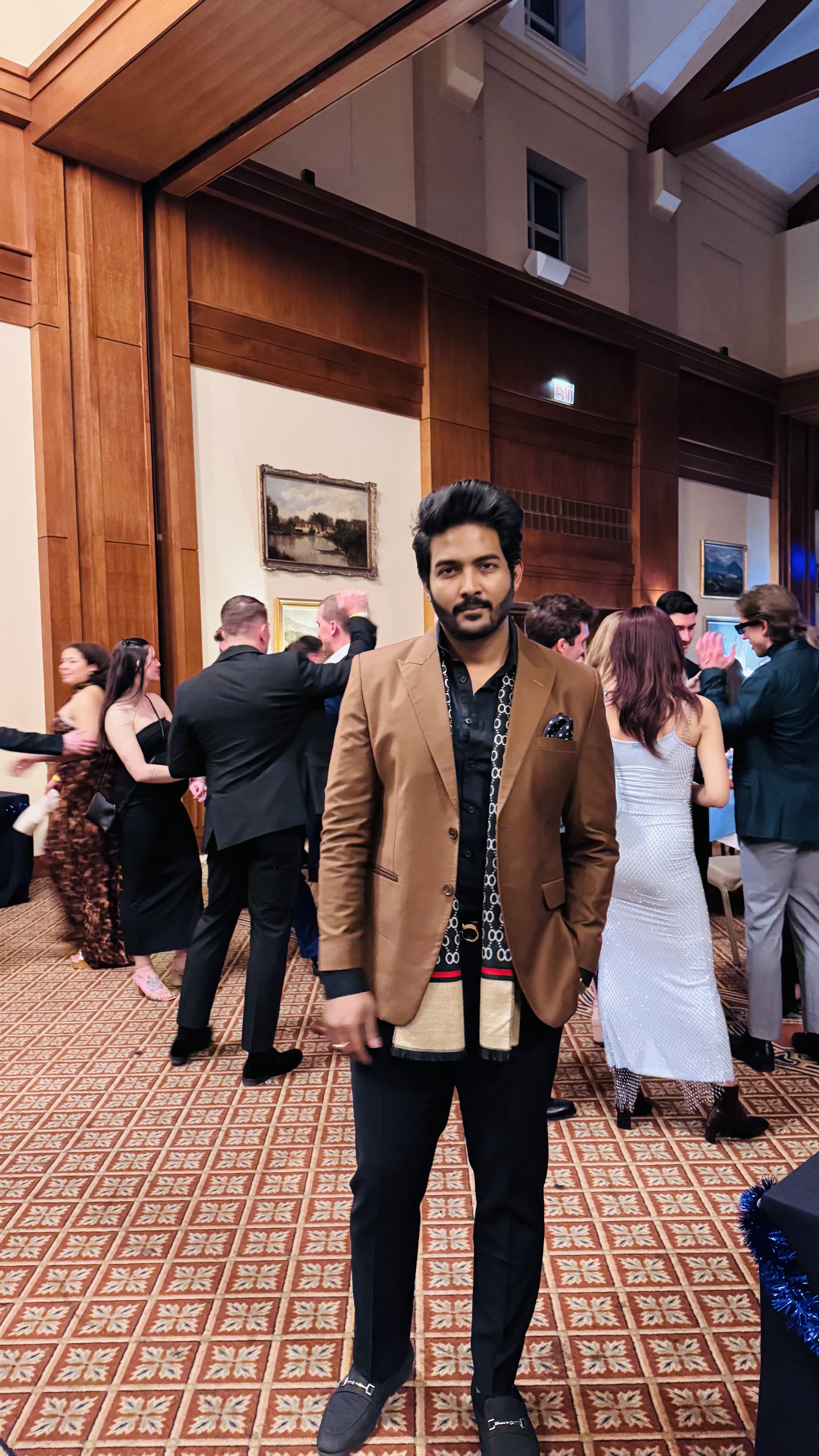 Teja in a tan blazer at an evening event.